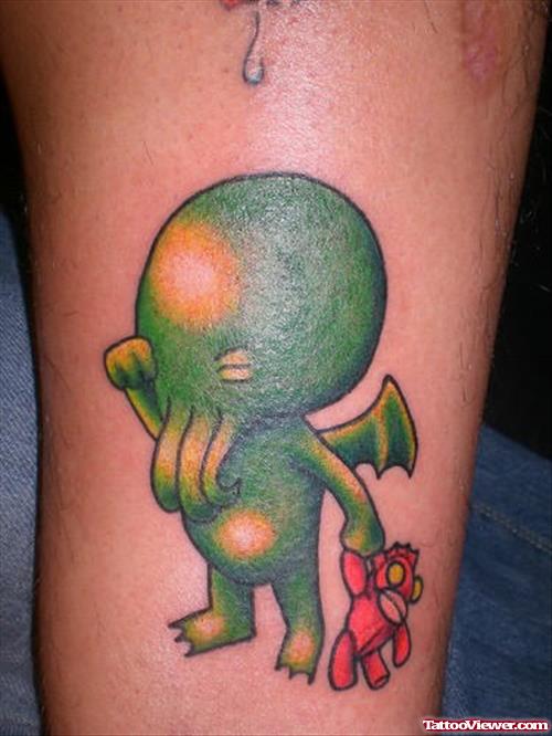 Green Ink Alien With Teddy In Hand Tattoo