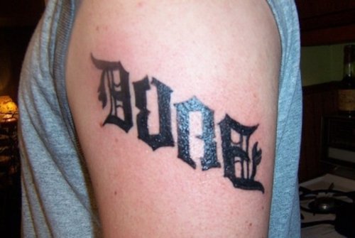 Black Ink Ambigram Tattoo On Left Shoulder