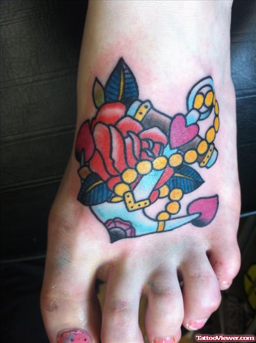 Color Flower And Anchor Tattoo On Left Foot