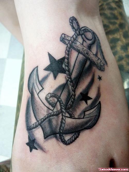 Grey Ink Stars And Anchor Tattoo On Left Foot