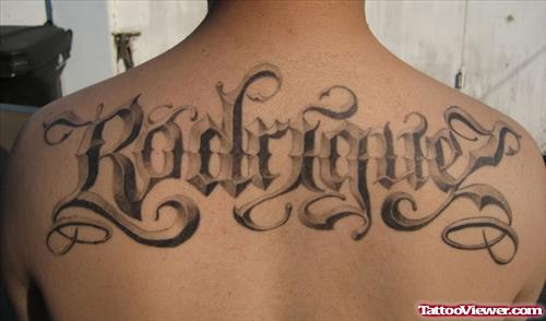 Grey Ink Animated Lettering Tattoo On Upperback