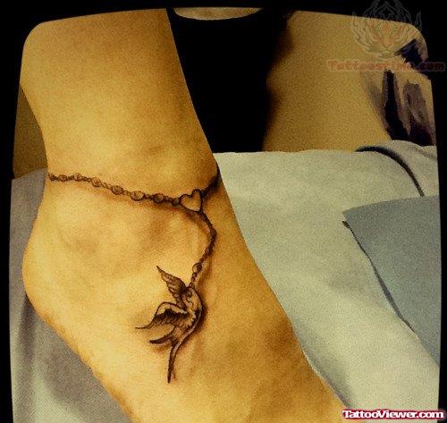 Grey Ink Rosary Bird Ankle Tattoo