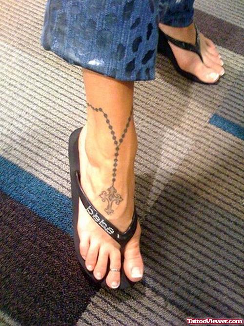 Attractive Grey Ink Rosary Cross Ankle Tattoo