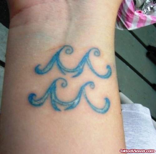 Blue Ink Aquarius Tattoo On Wrist