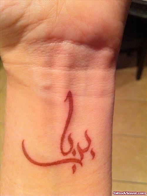 Red Ink Arabic Tattoo On Wrist
