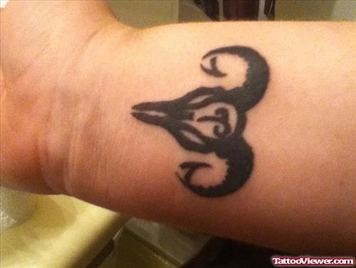 Black Ink Tribal Aries Tattoo On Wrist