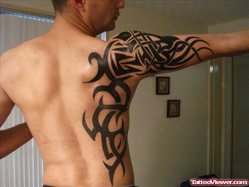 Black Ink Tribal Tattoo On Side And Right Arm