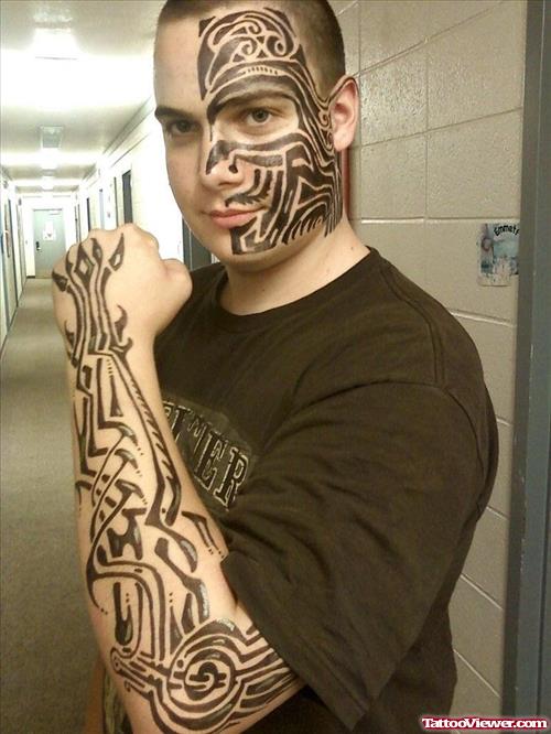 Black Ink Tribal Tattoo On Face And Left Arm