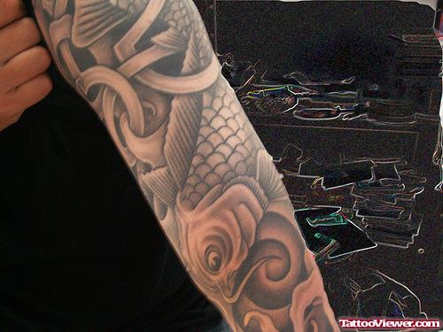 Grey Ink Tribal And Fish Tattoo On Arm