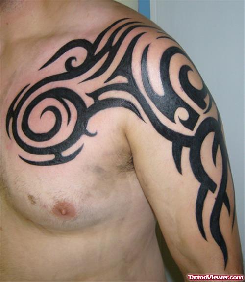 Black Tribal Tattoo On Man Chest And Left Arm