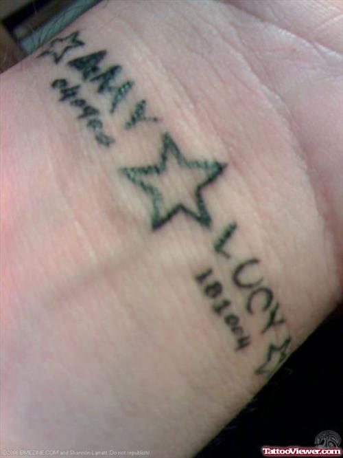 Black Ink Star And Baby Names Tattoo On Wrist