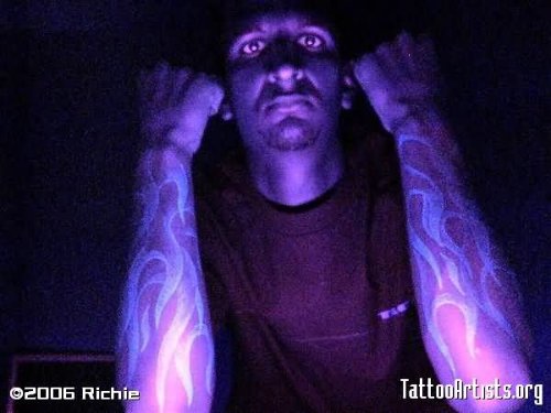 Guy Showing His Both Arms Black Light Tattoos