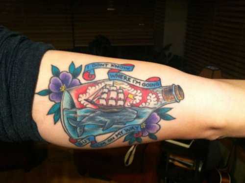 Color Flowers And Sailor Ship Bottle Tattoo On Bicep
