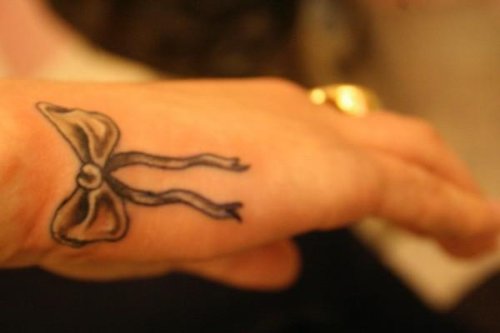Grey Ink Bow Tattoo On Right Hand