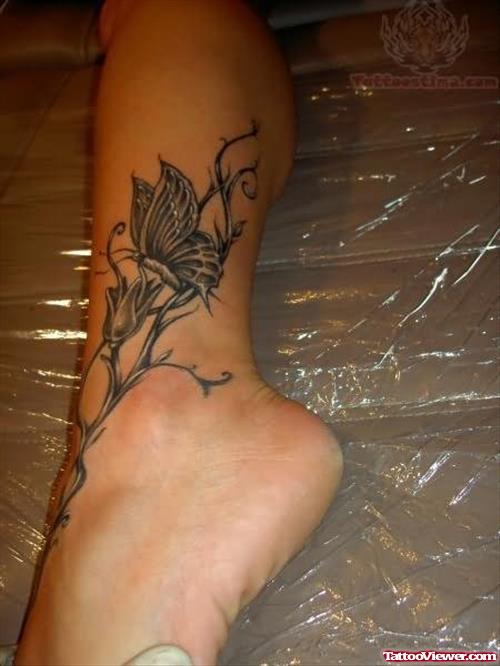 Grey Ink Butterfly And Flower Tattoo On Ankle