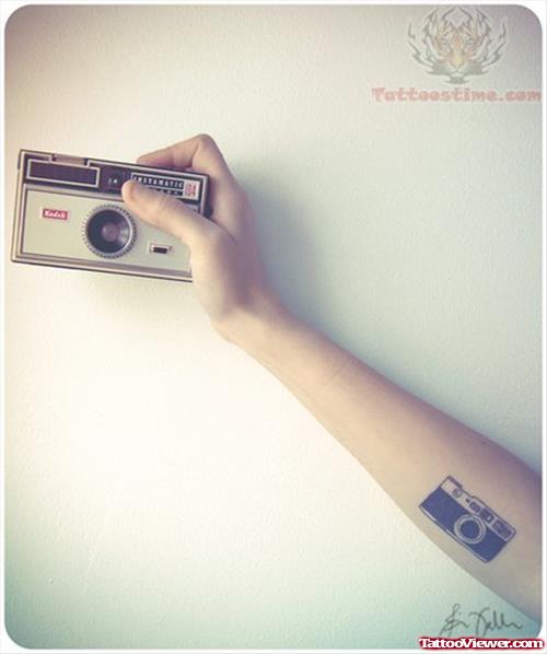 Camera In Hand And Tattoo On Arm