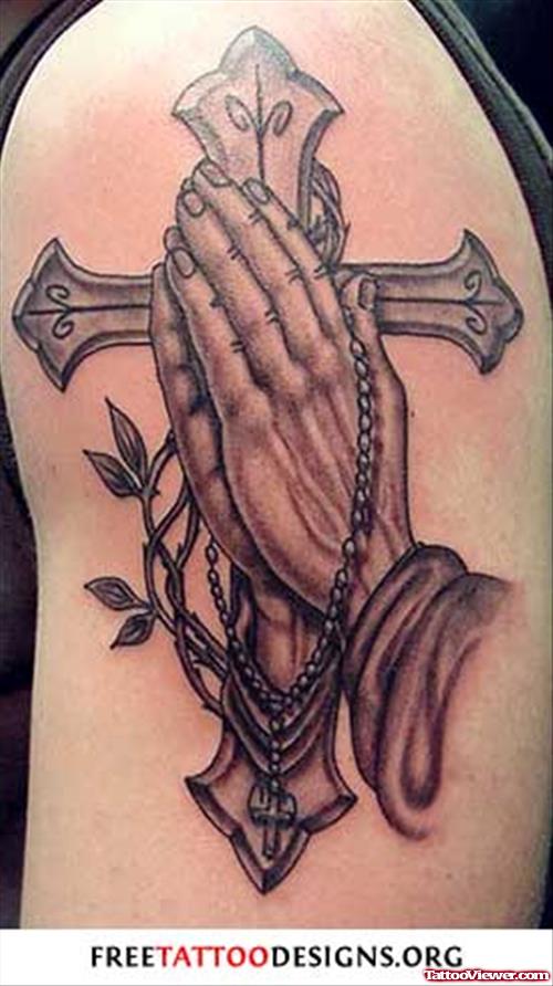 Praying Hands And Grey Ink Cross Tattoo On Shoulder
