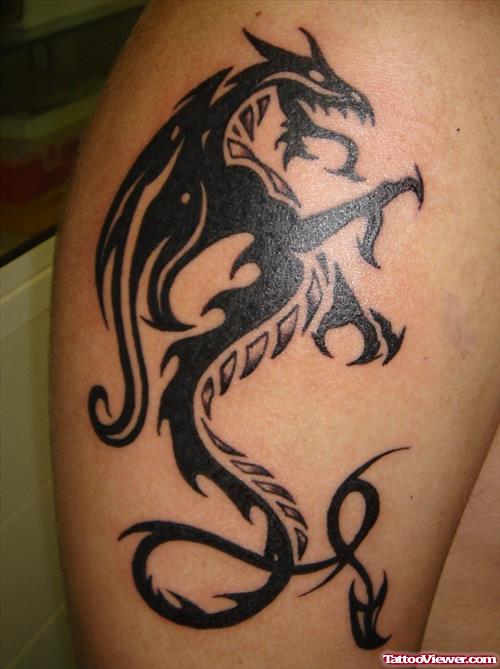 Black Ink Tribal Dragon Tattoo On Bicep