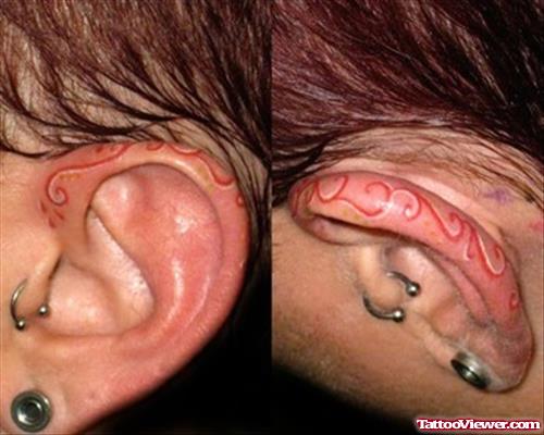 Red Ink Tattoo On Left Ear