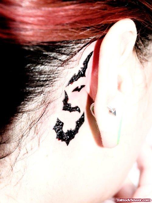 Black Ink Flying Bats Behind Ear Tattoo
