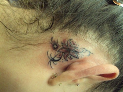 Cute Girl With Flower Behind Ear Tattoo