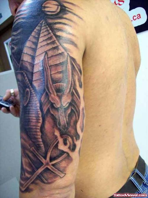 Grey Ink Egyptian Tattoo On Man Left Sleeve