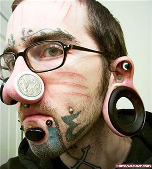 Tribal And Extreme Tattoo On Man Face