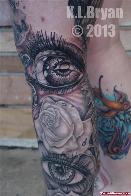 Grey Ink Eye And Grey Rose Flower Tattoo On Leg