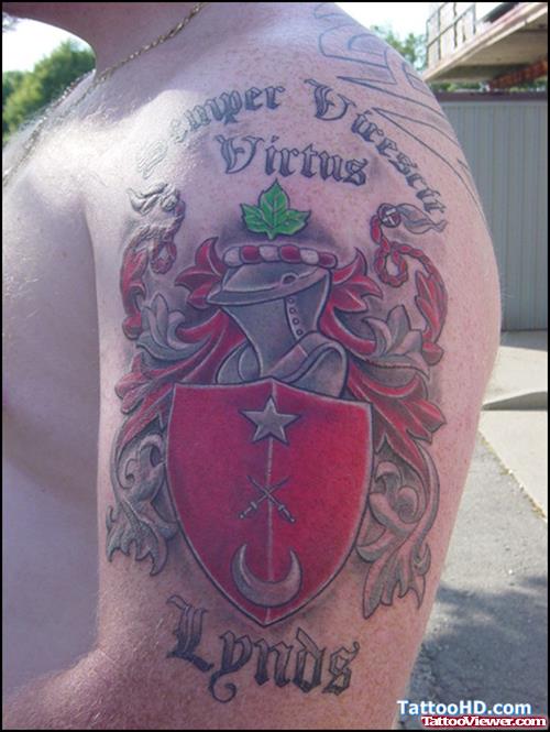Man With Colore Family Crest Tattoo On Left SHoulder