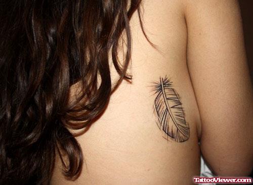 Small Grey Feather Tattoo On Side