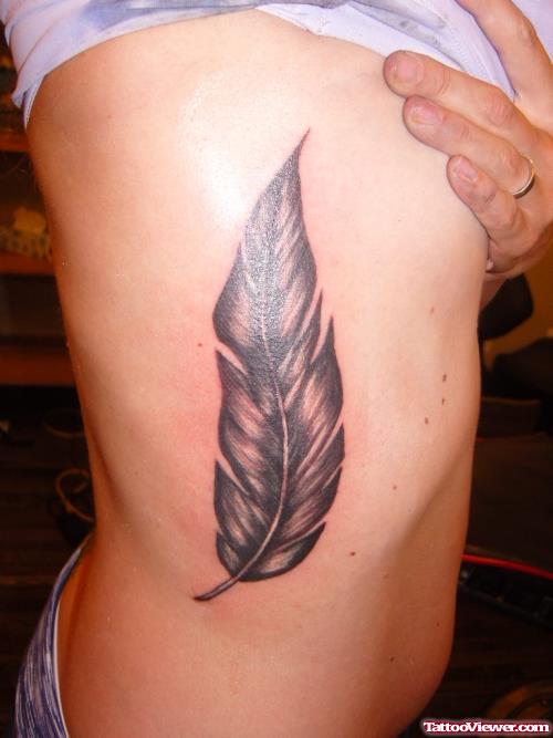 Grey Ink Rib Feather Tattoo