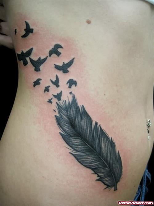 Small Birds Flying From Feather Tattoo On Rib