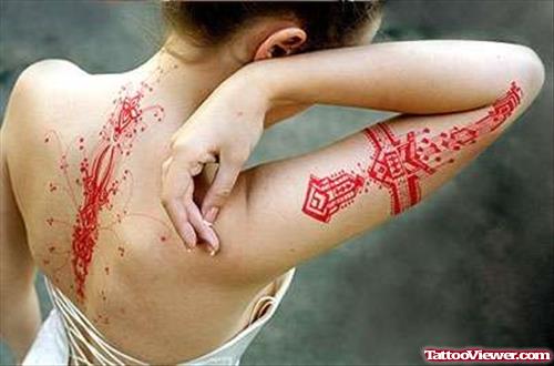 Red Ink Feminine Tattoo On Back And Half Sleeve
