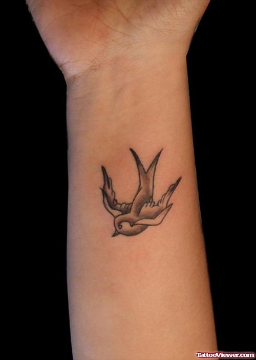 Grey Ink Flting Bird Feminine Tattoo On Wrist
