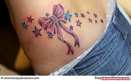 Colored Stars And Bow Feminine Tattoo On Side Rib