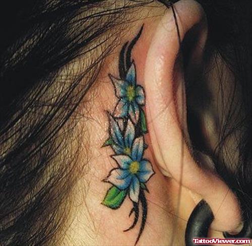 Blue Ink Flowers And Tribal Feminine Tattoos Behind Ear