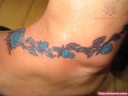 Blue Ink Feminine Tattoo On Ankle
