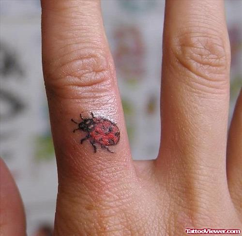 Red Ink Ladybug Finger Tattoo