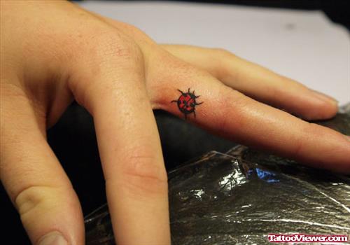 Red Ink Lady Bug Finger Tattoo