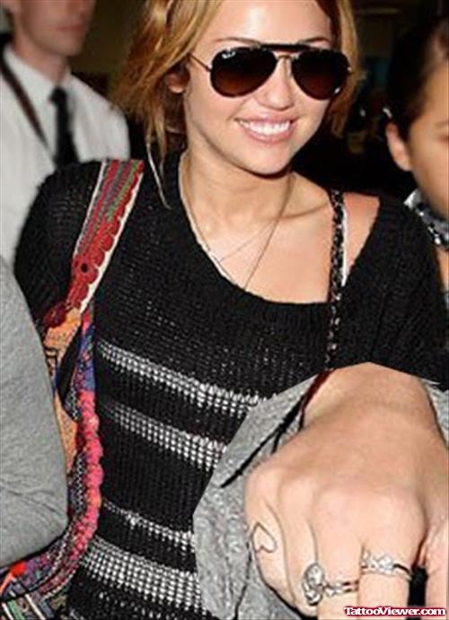 Attractive Miley Cyrus With Heart Finger Tattoo
