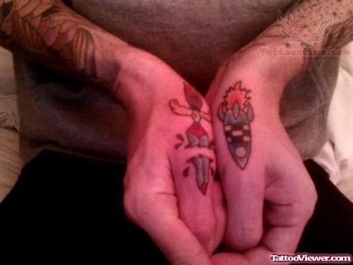 Dagger And Miscile Tattoos On Thumbs