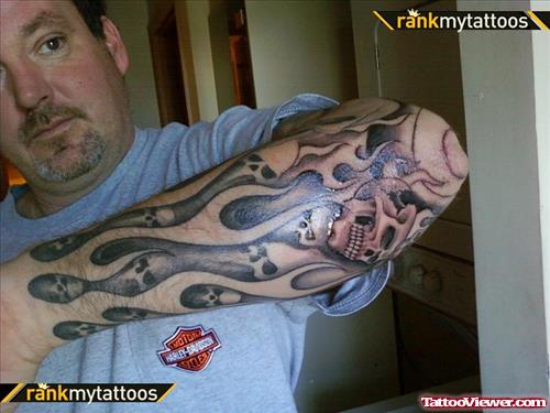 Grey Ink Skulls And Flames Tattoo On Man Left Sleeve