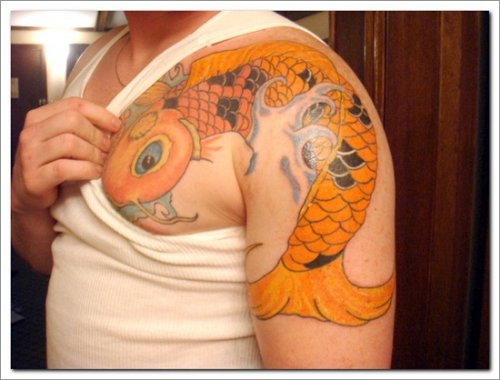 Man Showing Fish Tattoo On Left Shoulder