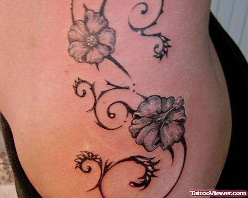Grey Ink Tribal And Flower Tattoo On Side