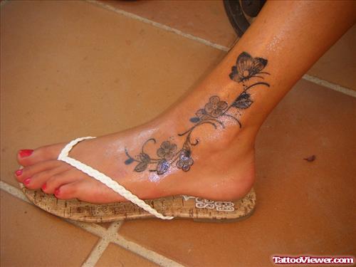 Grey Ink Flowers And Butterfly Foot Tattoo
