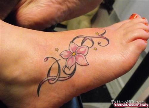 Grey Ink Tribal And Pink Flower Tattoo On Right Foot