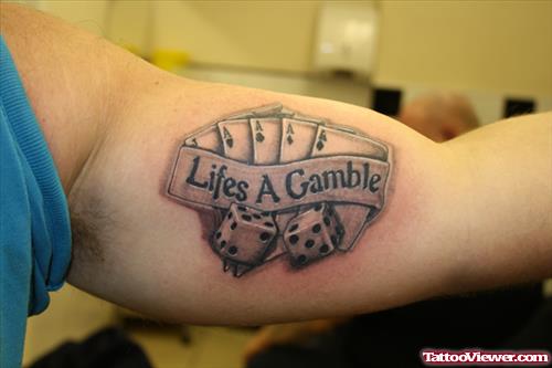 Lifes A Gamble Grey Ink Tattoo On Bicep