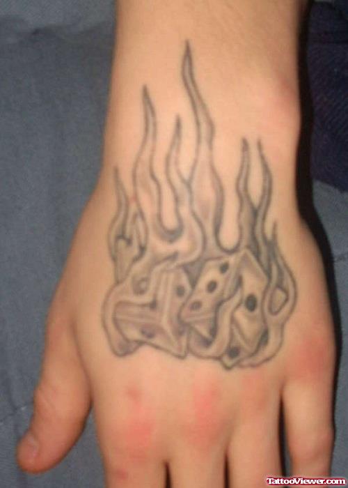 Grey Ink Flaming Dice Gambling Tattoo On Hand