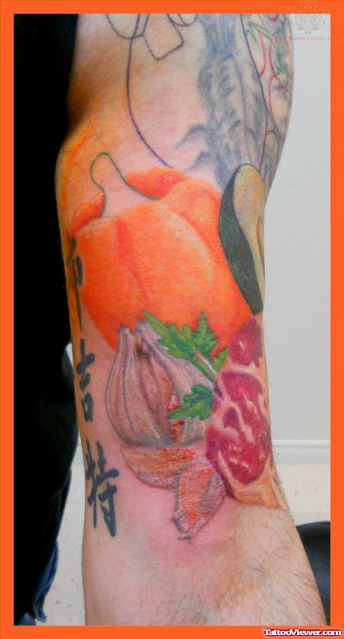Colored Pumpkin And Garlic Tattoo On Left Bicep