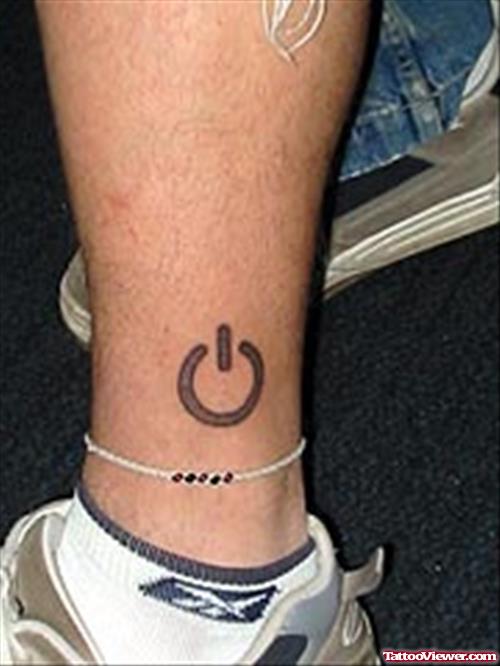 Grey Ink Power Button Tattoo On ankle